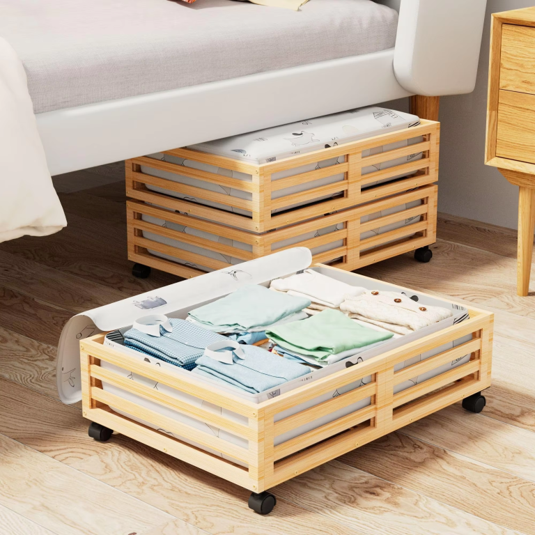 Bamboo underbed storage frames with horizontal slats and black wheels, pictured with printed fabric bags and folded clothing beside a bed
