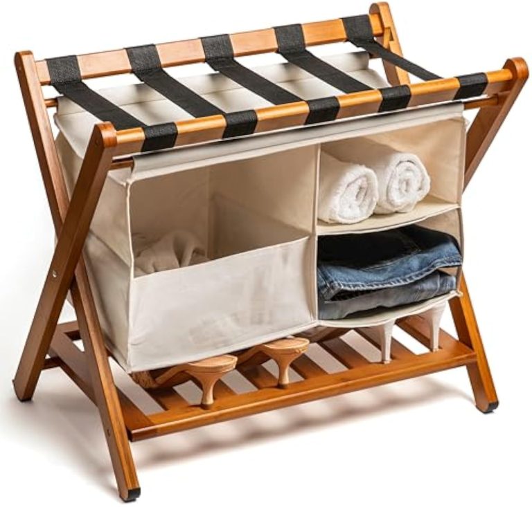 Bamboo luggage rack with black top straps, a hanging fabric organizer and a lower slatted shelf, pictured with towels, clothing and shoes