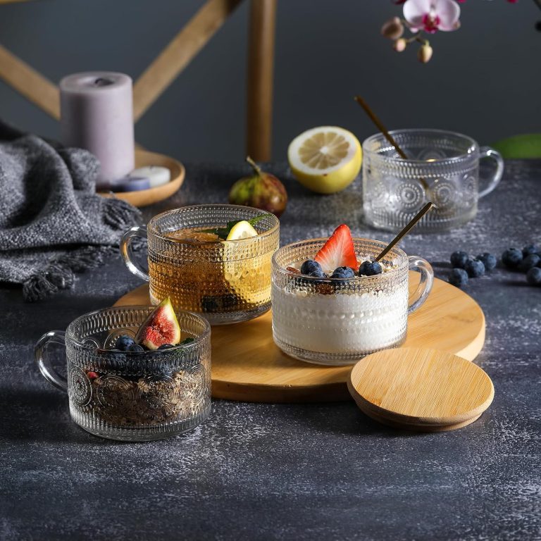 Embossed glass mugs arranged with fruit, yogurt and a drink beside a bamboo lid