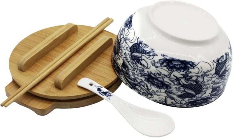Underside of the fish-pattern ceramic bowl beside its spoon, bamboo lid, chopsticks and trivet