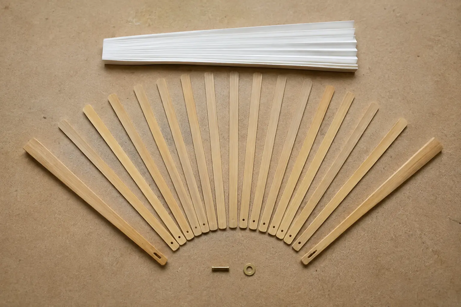 Exploded view of a bamboo hand fan frame with guard sticks, inner staves, pivot and paper leaf