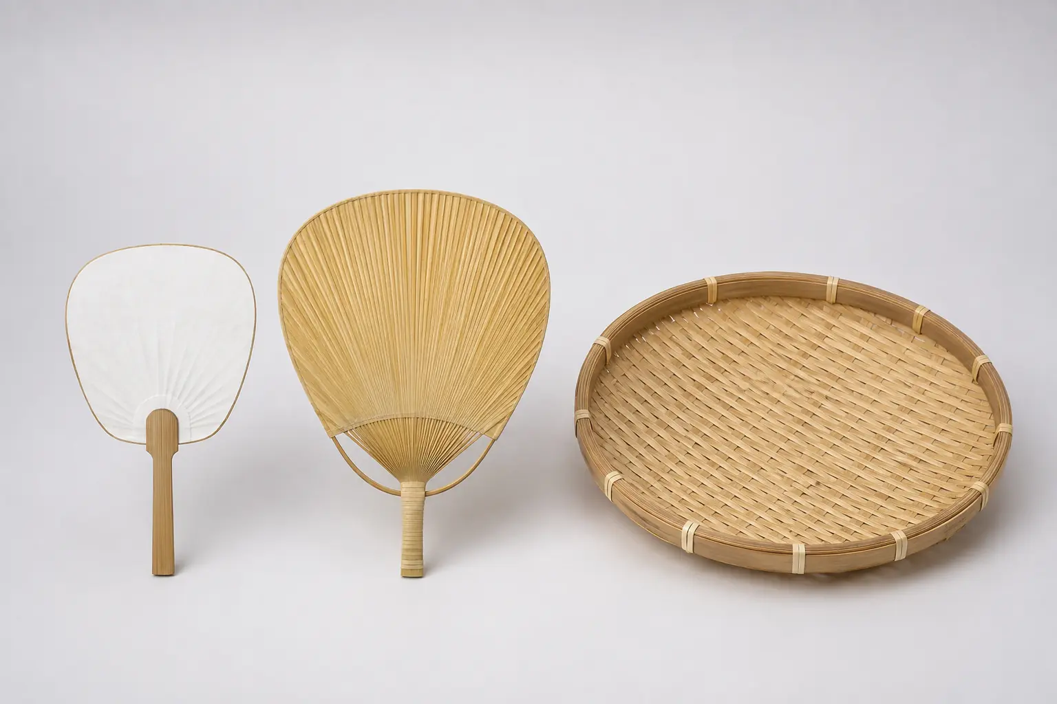 Rigid bamboo paddle fan, uchiwa-style hand fan and woven winnowing tray shown separately