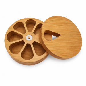 Bamboo pill organizer with seven compartments and rotating lid on white background