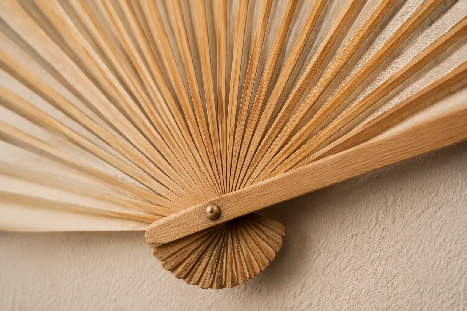 Close view of natural bamboo ribs, pivot and edge finish on a wall hanging fan
