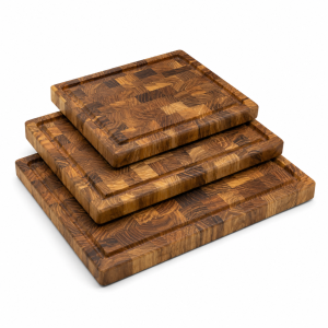 Teak cutting board set product concept showing three graduated warm-brown block-pattern boards with juice grooves