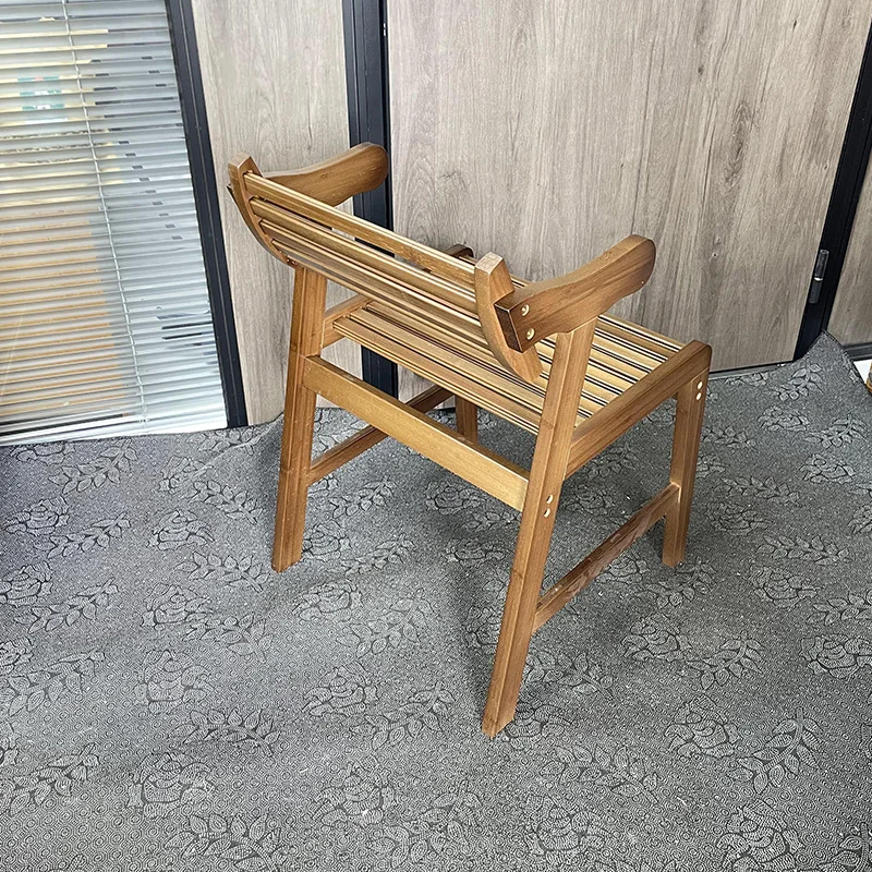 Rear three-quarter view of a bamboo armchair showing the back slats, frame rails, leg stretchers, and armrest connections.