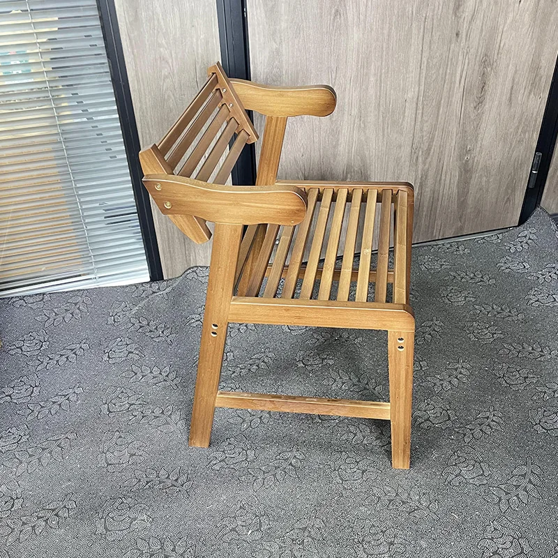 Side view of a bamboo chair showing the slatted seat, angled backrest, curved arms, stretchers, and visible fasteners.