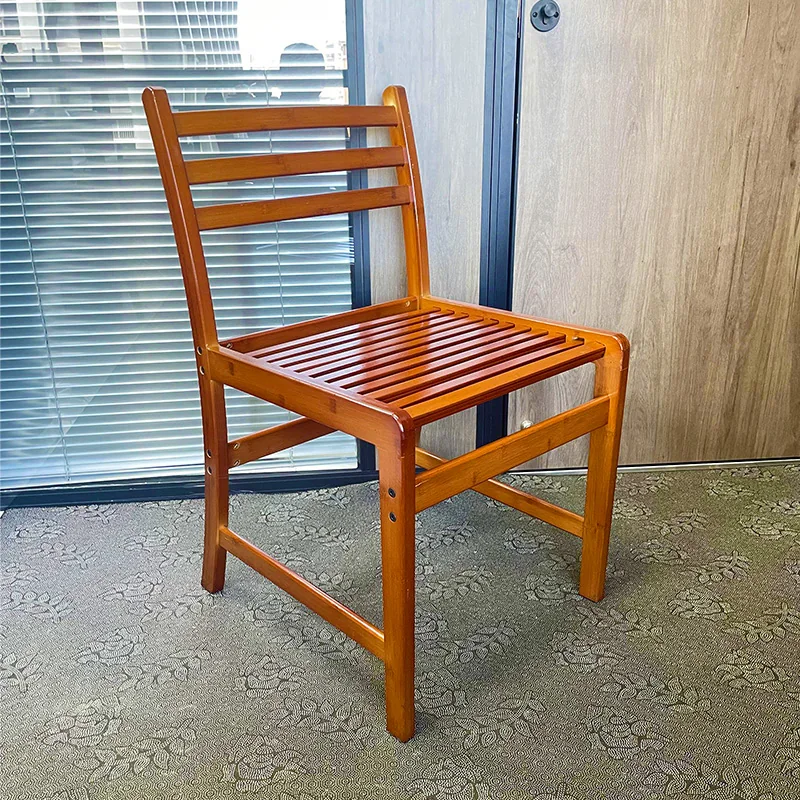 Honey-finished bamboo chair with a ladder back and slatted seat, shown from a three-quarter angle.