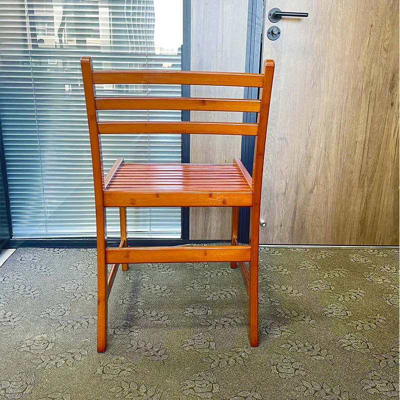 Rear view of a honey-finished bamboo dining chair with three horizontal back rails.