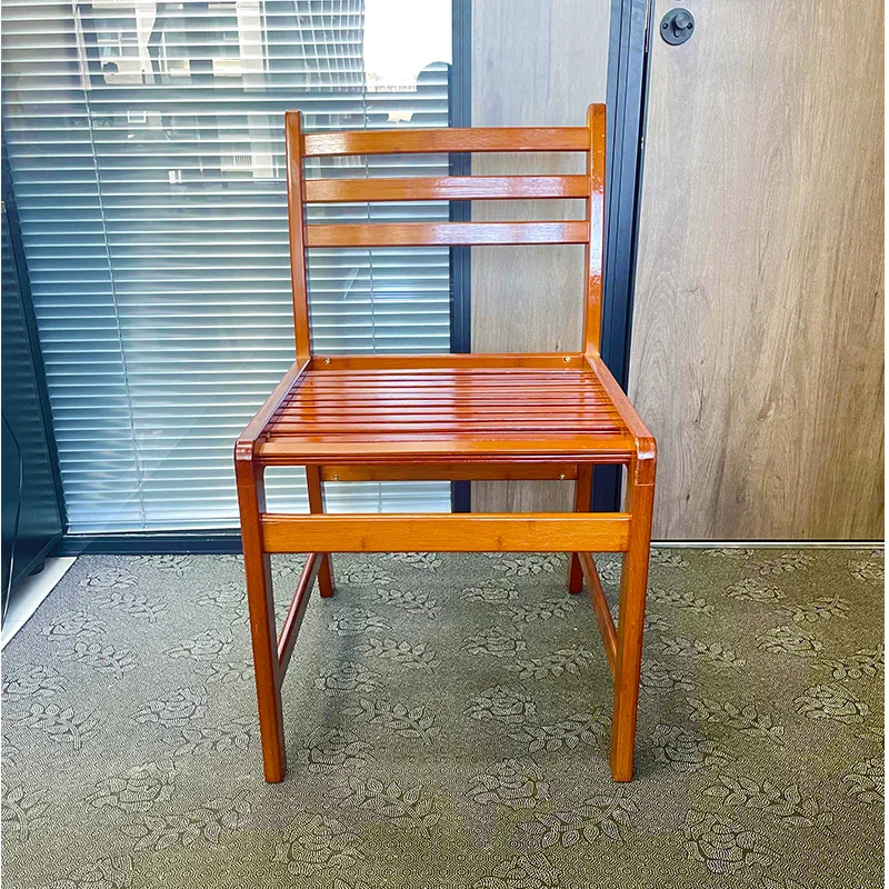 Front view of a honey-finished bamboo dining chair with a slatted seat and three-rail back.